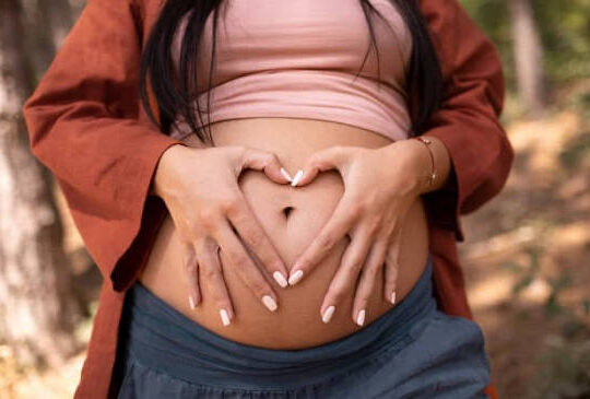 mujer embarazada con manos en su panza